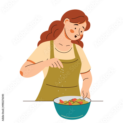Contented woman in an apron add seasonings onto a fresh salad. Cooking scene featuring healthy food