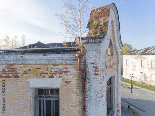Old brick building with moss roof in bright daylight outdoor scene