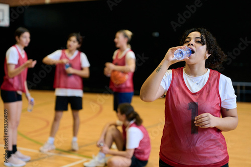 Принти на полотні Female basketball player drinking water during break