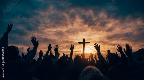 Crowd gathers outdoor for worship service with hands raised at sunset under cloudy sky