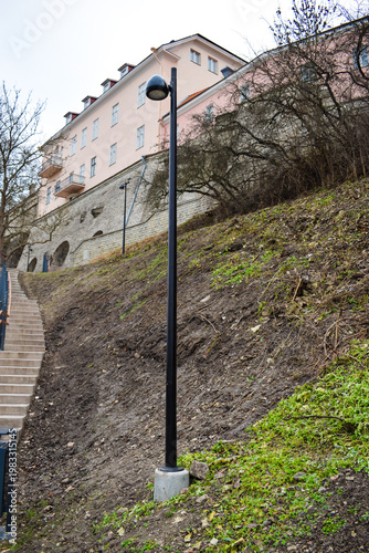 Modern Black Street Lamp on a Dirt Hill Below Historic Old Town Wall