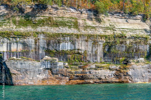 Moss-covered sandstone cliffs along Pictured Rocks National Lakeshore in Michigan Upper Peninsula viewed from tour boat.