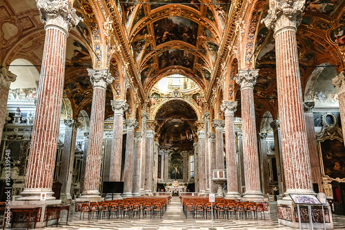 Symmetrical church interior with high ceilings columns and detailed ornamentation creating majestic and sacred architectural space, Genoa, Italy