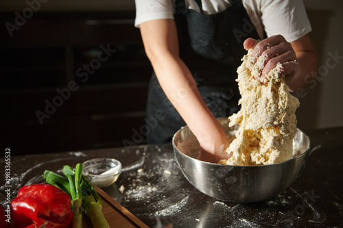 Принти на полотні Woman kneading fresh dough in bowl during cooking process