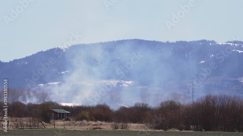 Smoke rising through the landscape as farmer burns field during the Spring in Wyoming.