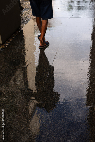  Pedestrian walking on reflection on the sidewalk