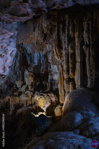 Foto Colorful illuminated limestone cave interior in Vietnam with massive stalactites