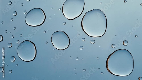 Drops of water or acid on a blue background, close-up