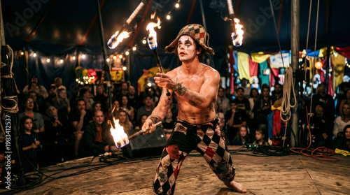 Juggler performing a fire show in a circus. Man in clown costume juggling flaming batons for an audience. Energetic entertainment and daredevil skill at a night performance event.