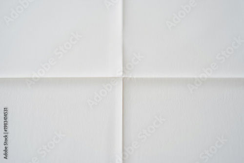 Abstract background of white paper folded in four creating intersecting lines and soft shadows
