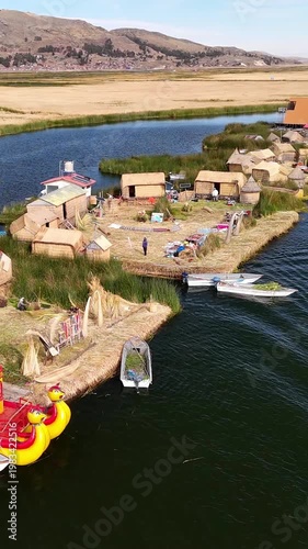 Aerial drone view of the floating Uros Islands on Lake Titicaca. The highest navigable lake in the world, located near Puno, Peru, South America. Popular travel destination.	