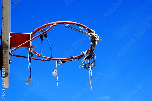 Tattered Basket Ball Hoop in Urban Inner City Park with Painted Lines for Basket Ball Court on Asphalt