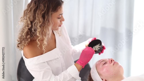 Aesthetician prepares a custom cleansing solution, carefully mixing ingredients for an effective skin treatment.