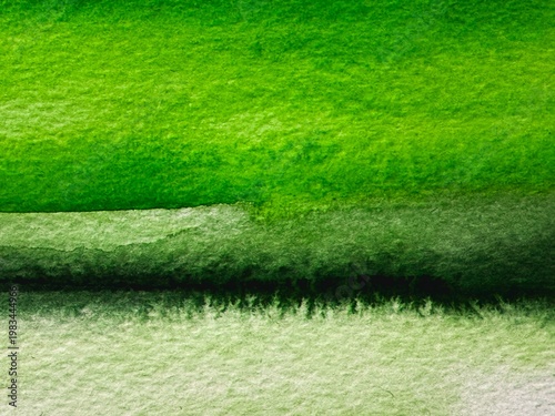 Abstract watercolor background in green tones with organic texture of paper and paint wash