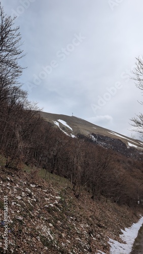 Vista da un sentiero di montagna, sotto un cielo coperto un paesaggio naturale maestoso.