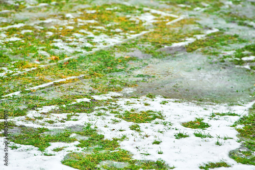 Foto Snow melting from grass in cold weather
