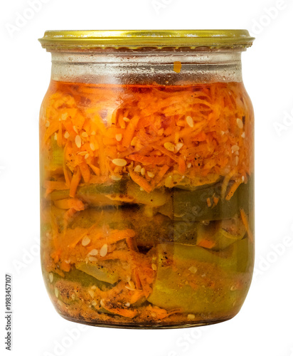 A jar holds layers of pickled vegetables. Carrots, cucumbers, and spices are mixed together. This food is prepared at home and can be used for meals or snacks