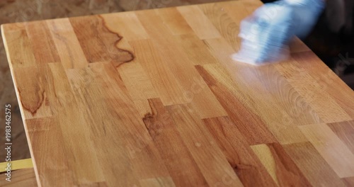 Laminated wood board finished with tung oil using piece of cloth, close up