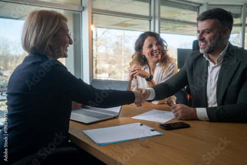 Young couple meeting financial advisor, agreement reached and handshake