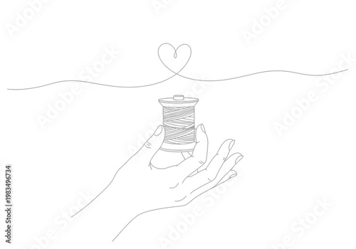 Hand holding a spool of thread with a continuous line forming a heart shape