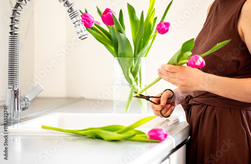Woman Trimming Tulips And Placing In Vase