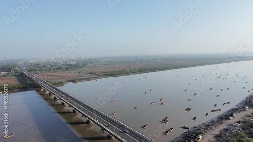 Aerial view of long bridge over Tapi River with vehicles and wide water landscape in Surat Gujarat India