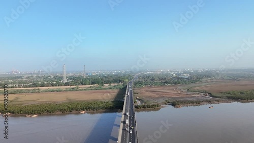 Straight road bridge over river connecting rural and urban areas in Surat Gujarat India aerial view
