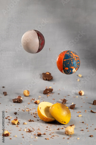 halves of multi-colored chocolate candies hang in the air