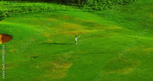 Aerial view of golfer drives a straight shot in the green golf course
