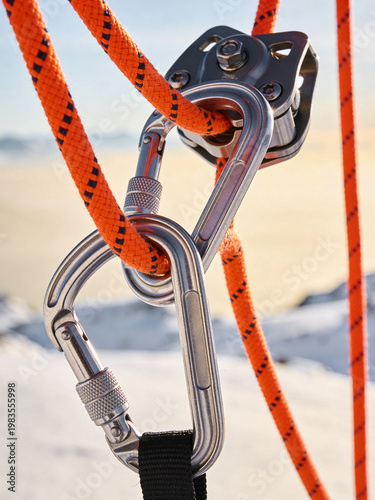 Professional Mountaineering Equipment with Steel Carabiners and Orange Ropes in the Snowy Mountains