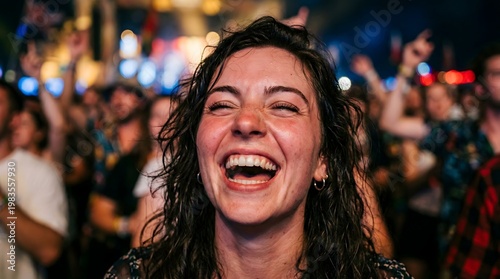 A woman laughs openly in a lively crowd with colorful lights in the background. Scene captures excitement, celebration, and high-energy social atmosphere.