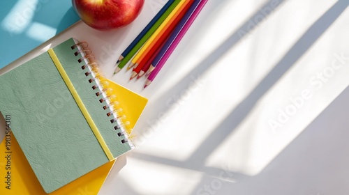 School Supplies on a Table With an Apple and Colored Pencils in a Bright Room...