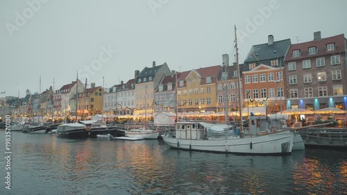 A scenic view of vibrant waterfront buildings lined with boats under a misty sky, creating a serene atmosphere perfect for relaxation and exploration.
