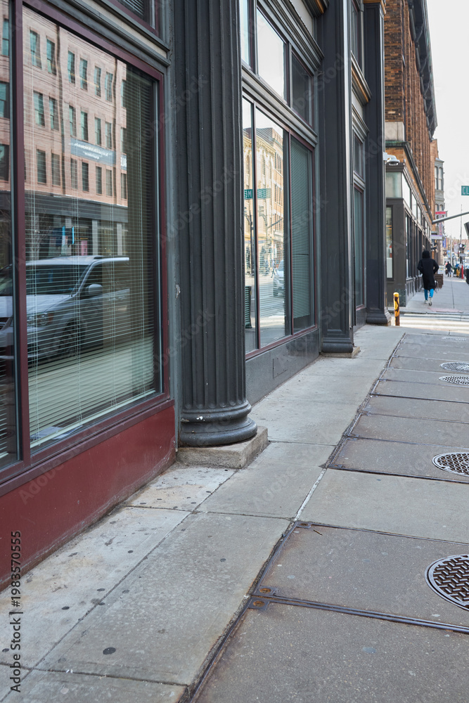 Obraz premium Person walking past storefront windows in city