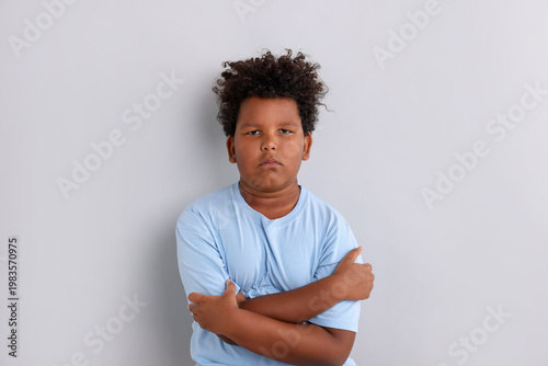 Photography Portrait of resentful little boy with crossed arms on grey background