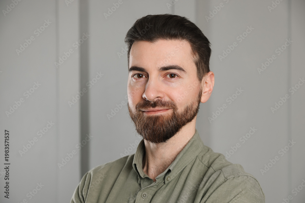 Fototapeta premium Portrait of handsome man near white wall indoors