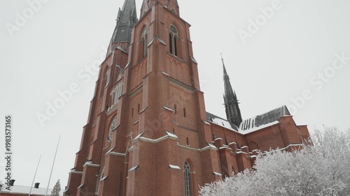 A breathtaking view of a majestic cathedral towering amidst a serene snowy landscape, showcasing intricate architecture against the white backdrop of winter.