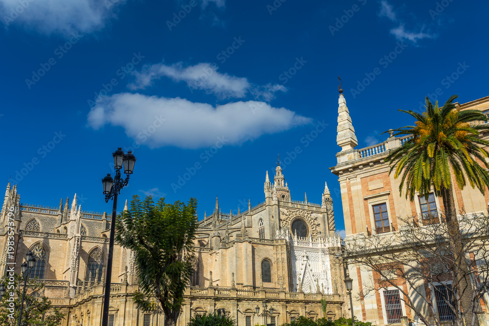 Fototapeta premium Seville, Andalusia, Spain, a stunning view of the historic cathedral and adjacent architecture under a bright blue sky, showcasing gothic details and a vibrant city scene on Feb 13, 2020