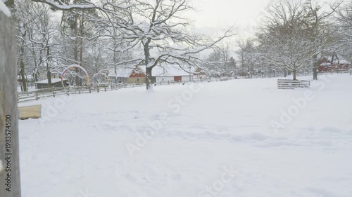 A serene winter scene showcasing snow-covered trees and a quaint farm surrounded by white landscapes. The quiet beauty of nature in winter invokes a peaceful atmosphere and highlights the charm of rur