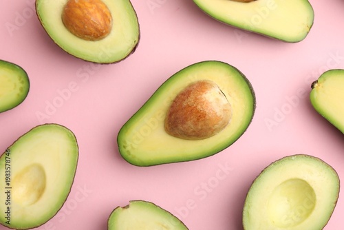 Cut fresh avocados on pink background, flat lay
