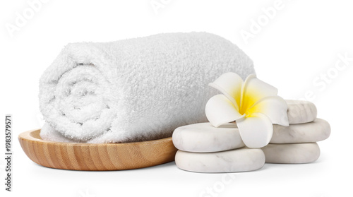 Fotografia Clean rolled towel, spa massage stones and plumeria flower isolated on white