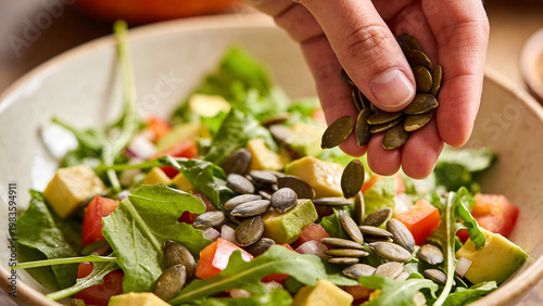 People prepare a salad with pumpkin seeds and fresh vegetables in an outdoor kitchen