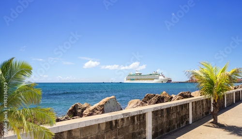 Seafront boulevard  with cruise ship on distance in port on sunny day