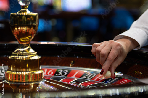 Closeup Of Dealer Placing Wager On Wheel. Focus On Hand Selecting Number On Roulette Game Table