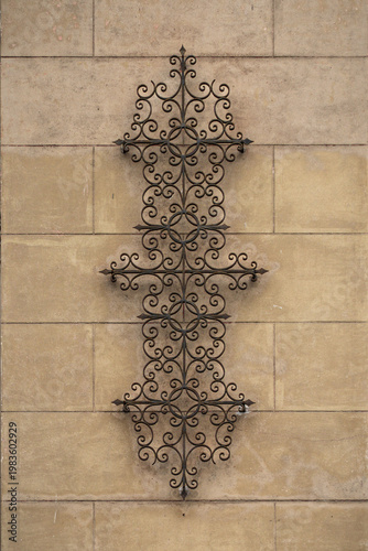 ornamental wrought iron wall decoration on stone facade