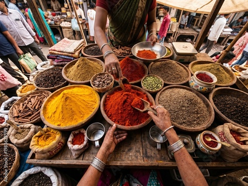 Colorful mounds of traditional spices in wooden bowls at authentic South Asian bazaar with vendor hands in warm natural light
