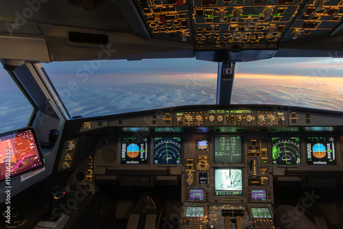 Fotografie Airplane cockpit view above clouds at sunset with instruments