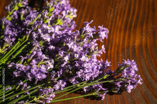 Macro shot of fresh purple lavender flowers bouquet on a rustic wooden table. Beautiful floral background for aromatherapy, spa, wellness and home decor concepts