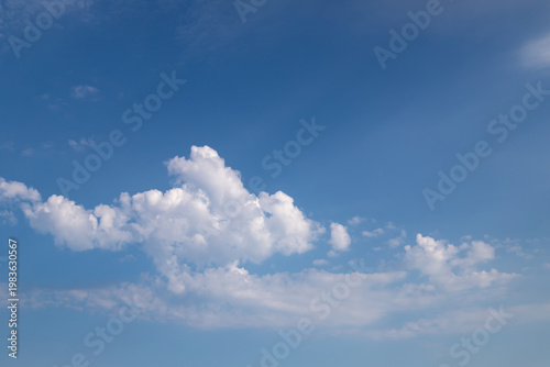 Cuadro en lienzo Soft cumulus clouds float across a vivid blue sky, evoking calm, openness and summer serenity