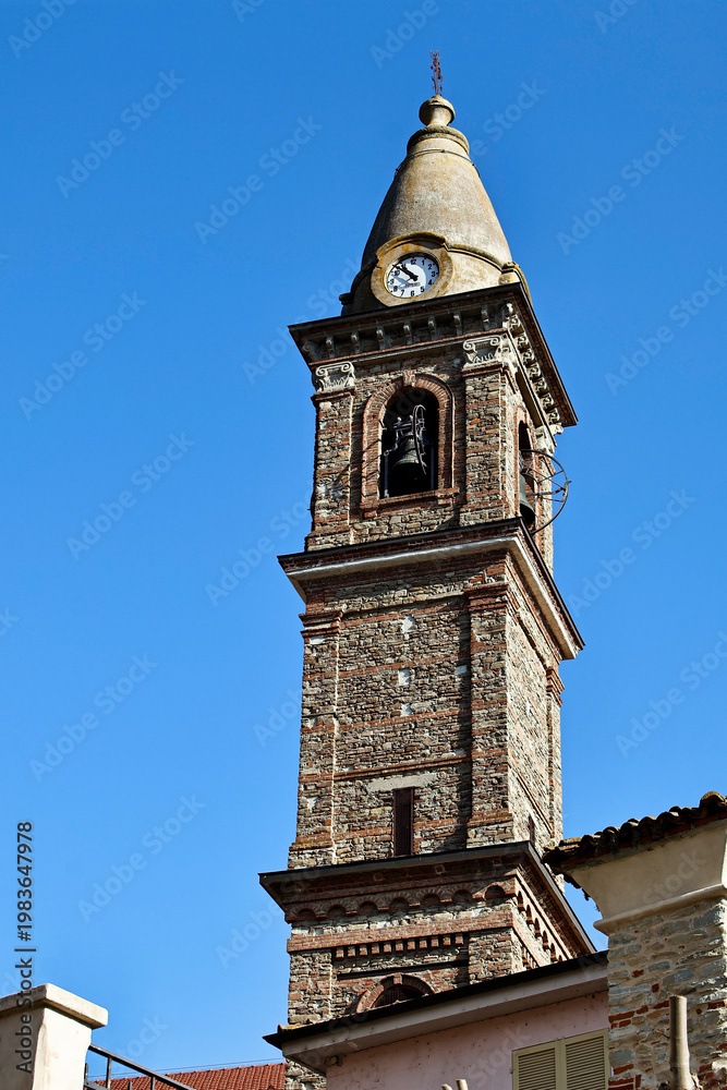 Obraz premium Ancient stone monastery in Monastero Bormida with bridge and chapel under blue sky. Sunny day with natural light highlighting stone texture. Historic Italian architecture, travel and cultural heritage